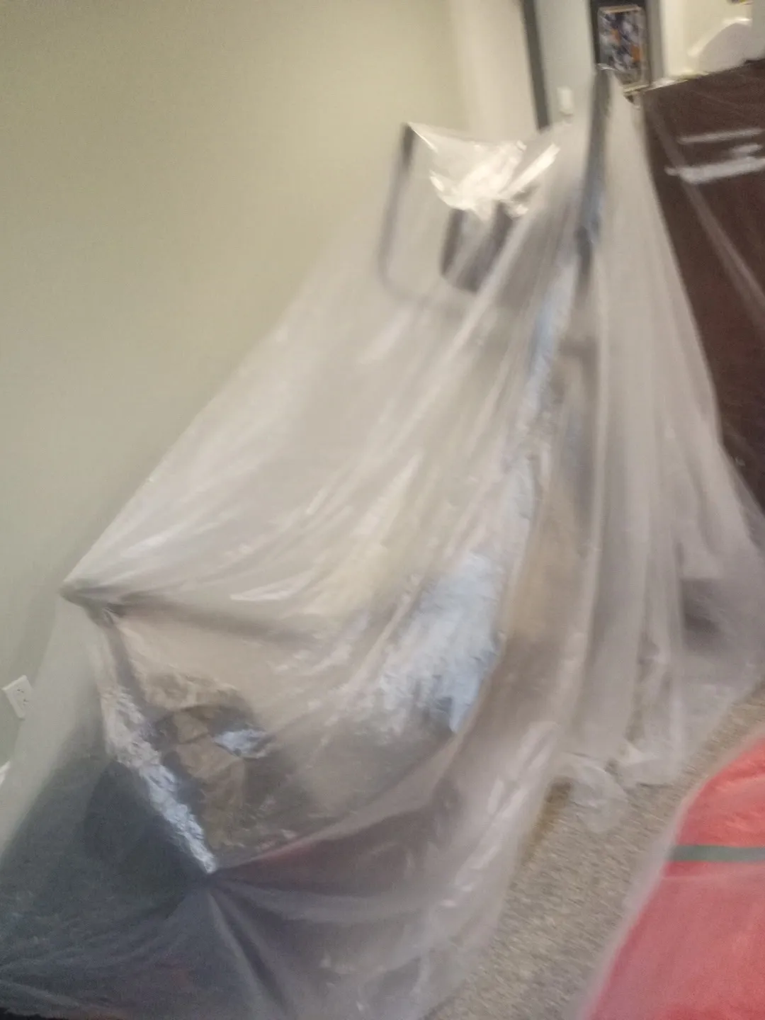 Furniture wrapped in plastic sheeting to protect it during painting