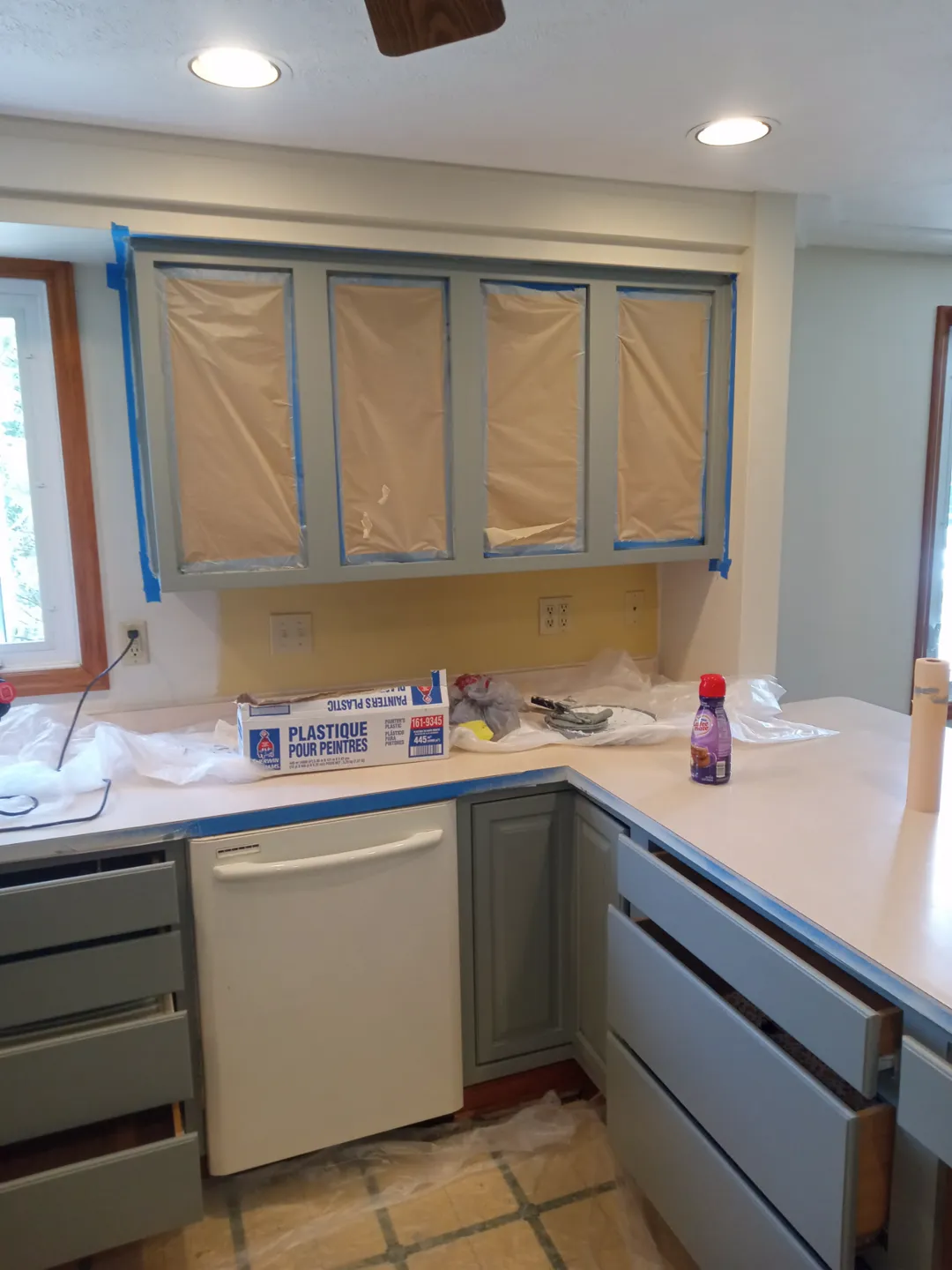 Upper cabinet frames painted with the counters covered in plastic