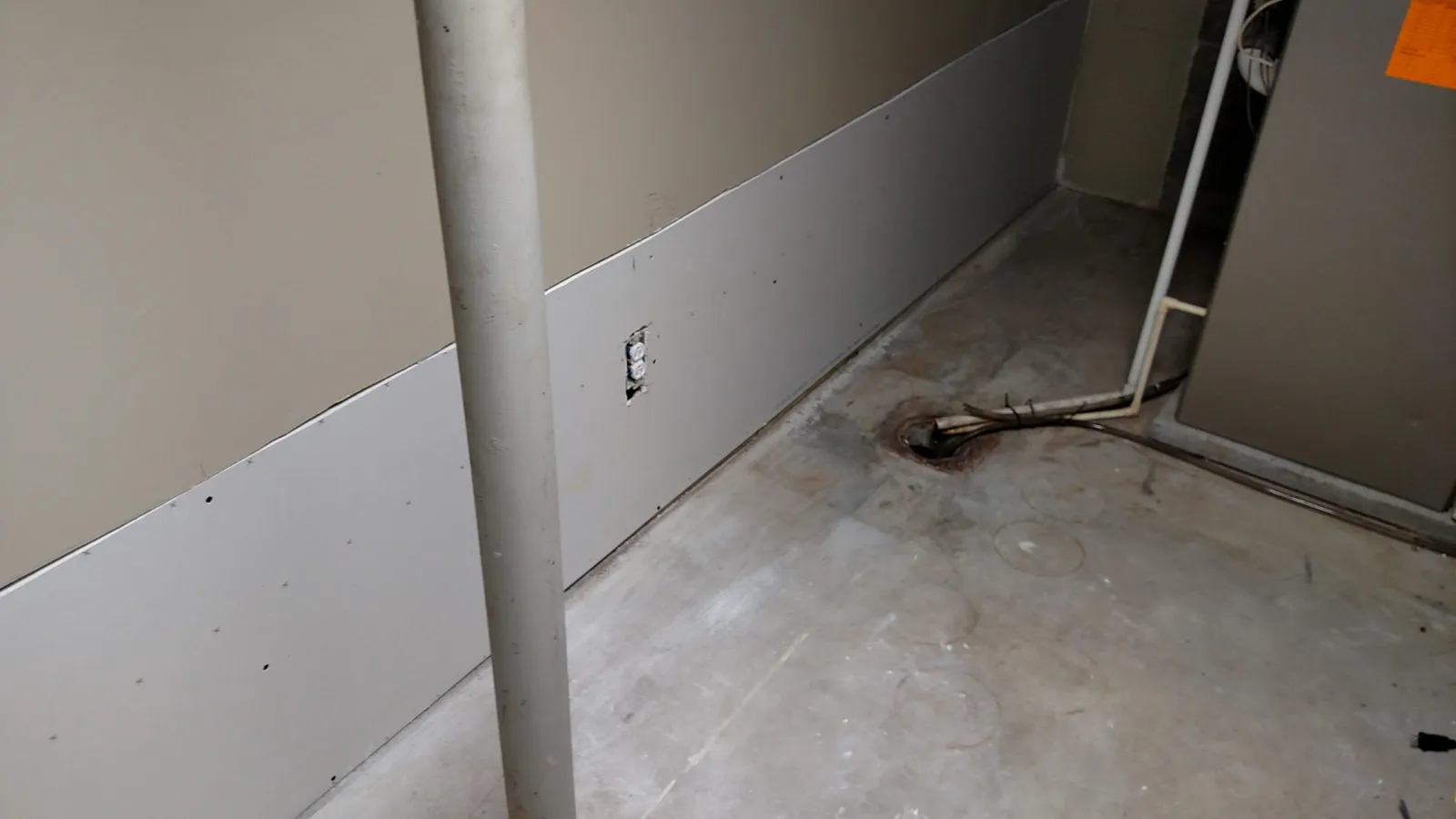 New lower drywall along a basement wall next to a support post