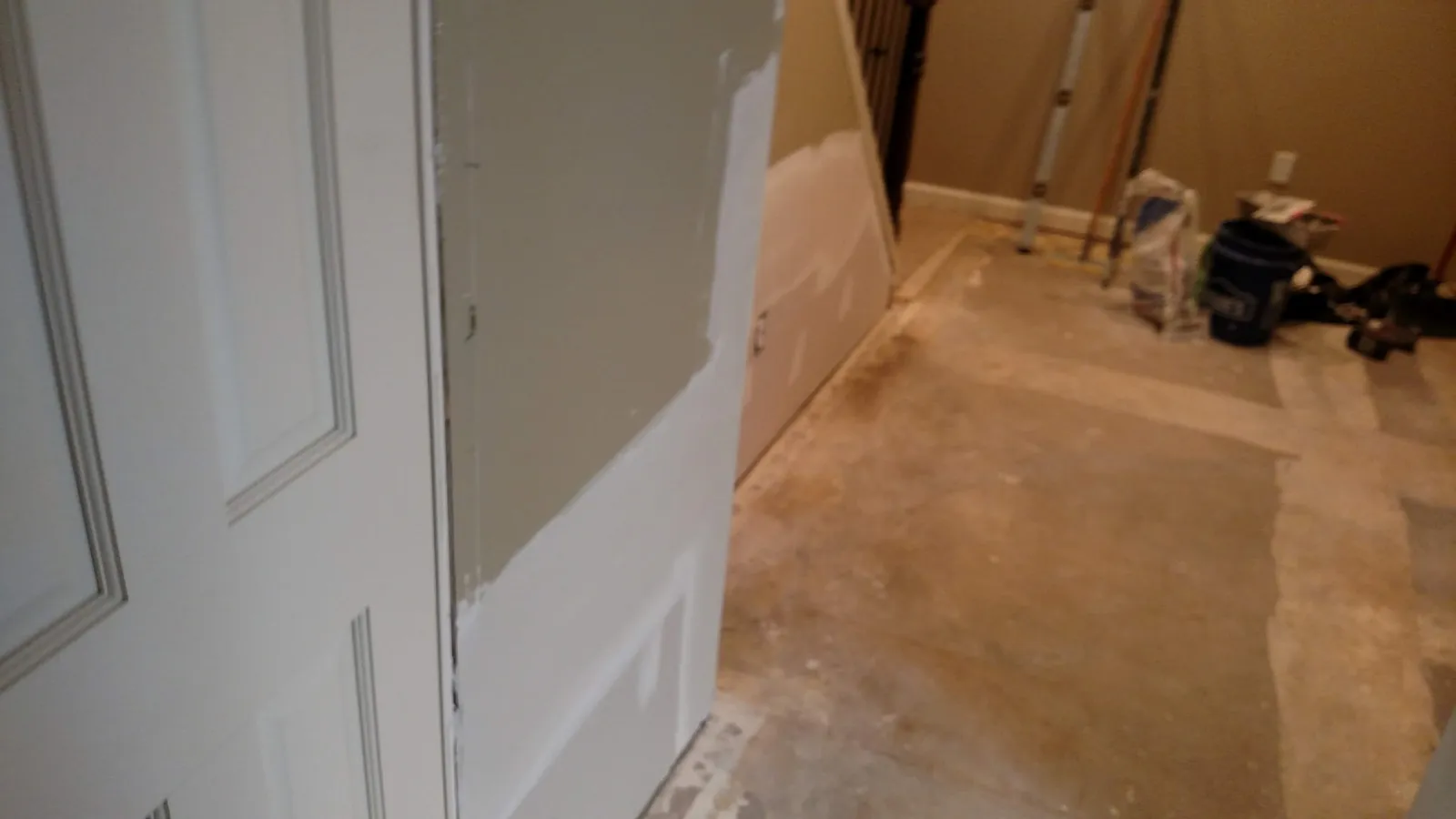 Drywall patch beside a door frame in a basement hallway