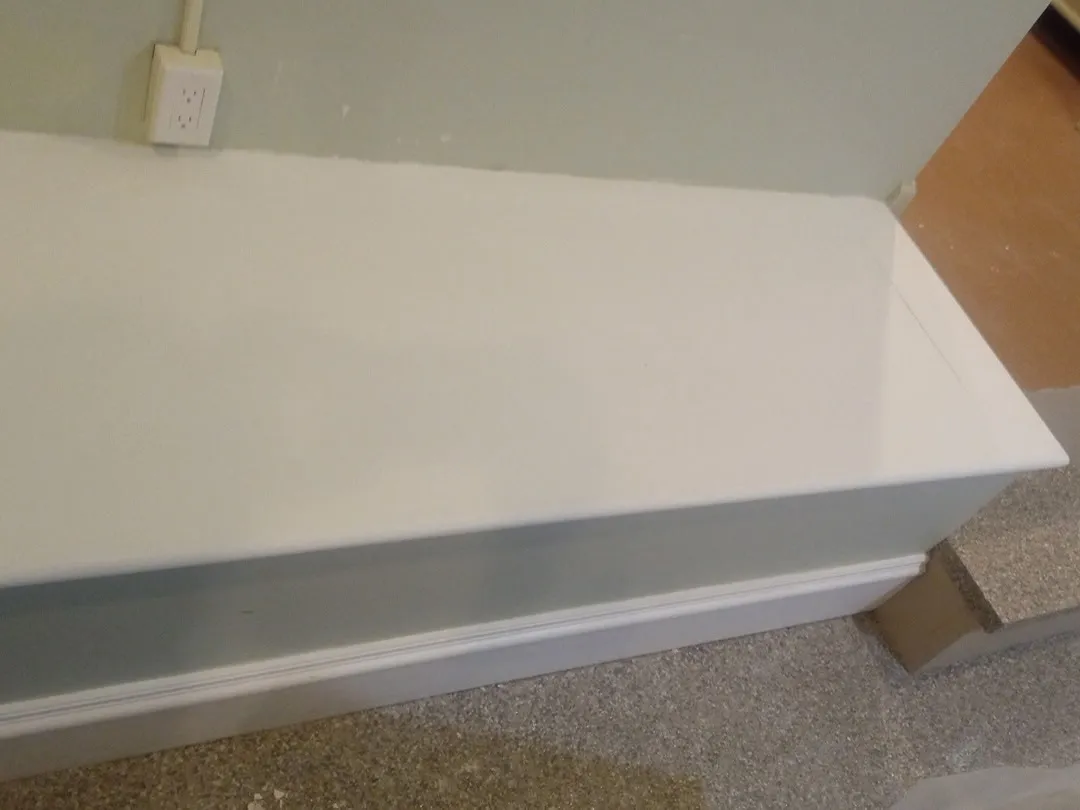 White painted built-in bench with a clean trim edge along the carpet