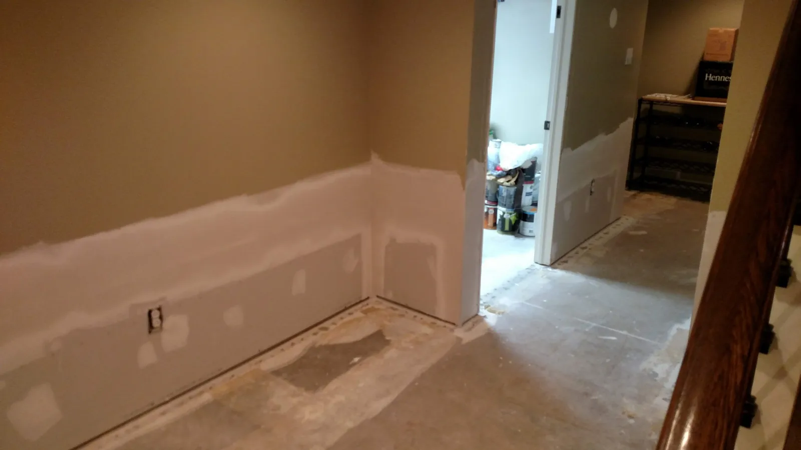 Basement room with finished drywall seams leading to a hallway