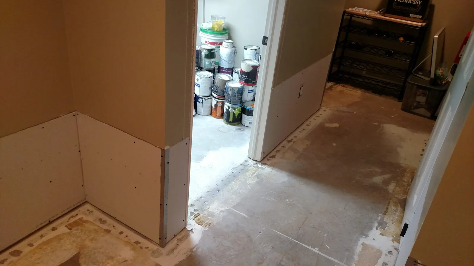 New drywall on a basement corner beside a storage room doorway
